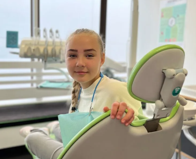 a teen sitting on a dental chair