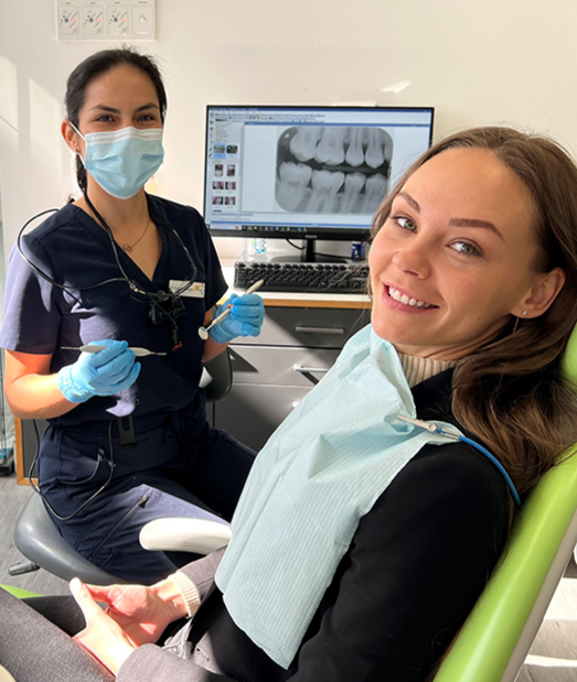 A dentist in epsom works with a happy patient at Alpers Dental