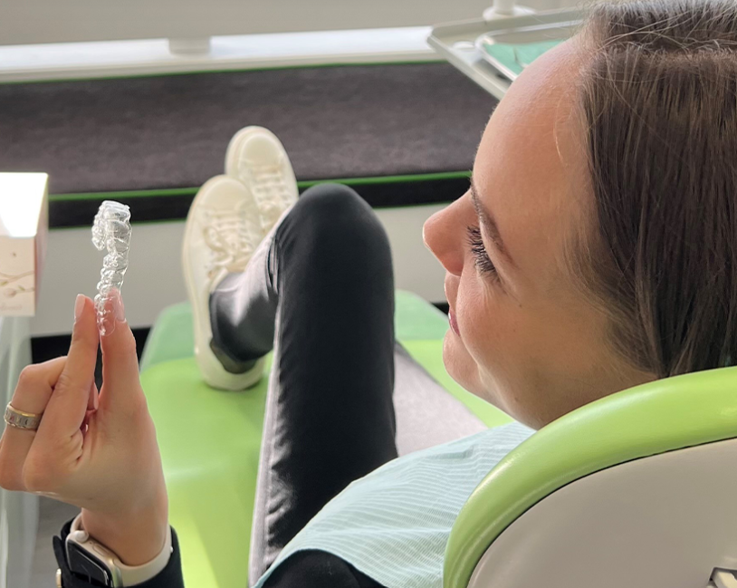 a person holding a clear aligner