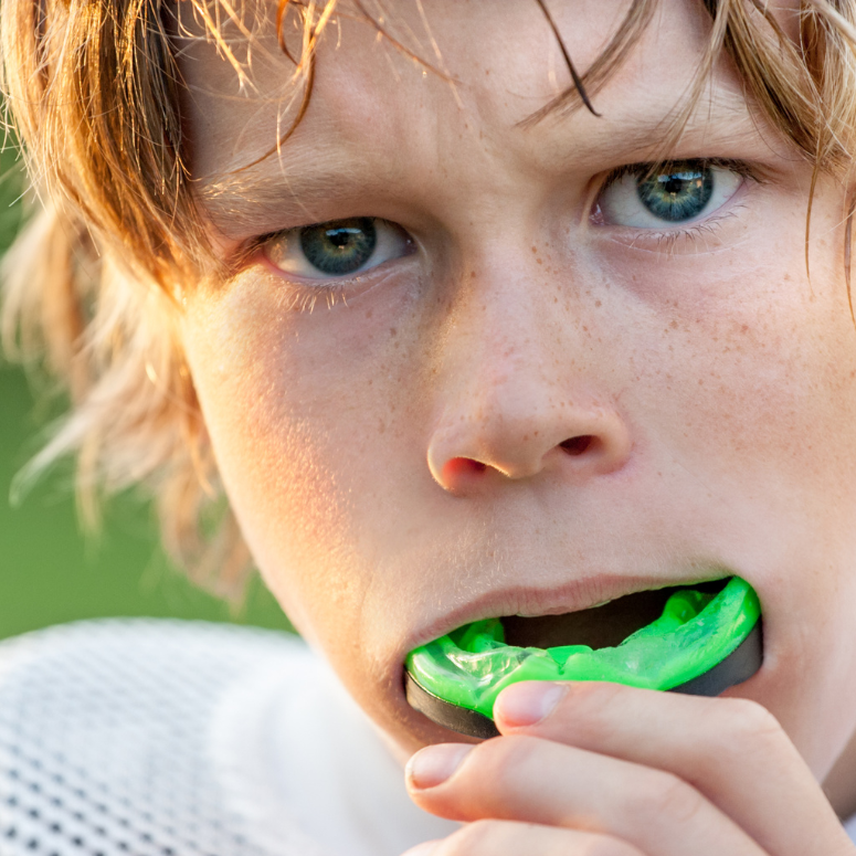 a child wearing a green mouthguard