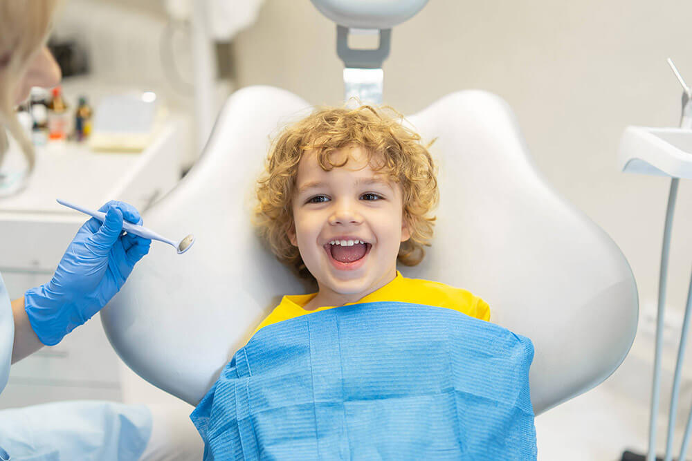 a little boy smiling in dental chair